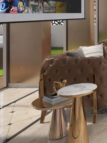 A detail shot of the custom-selected furniture, including polished gold side tables with marble tops and a classic chesterfield sofa. These pieces underscore the project's luxurious feel.