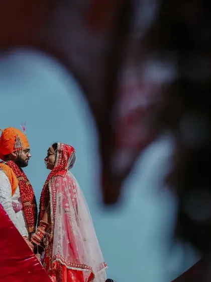 A creative, framed shot of the couple during their Varmala, creating a sense of intimacy and focus.