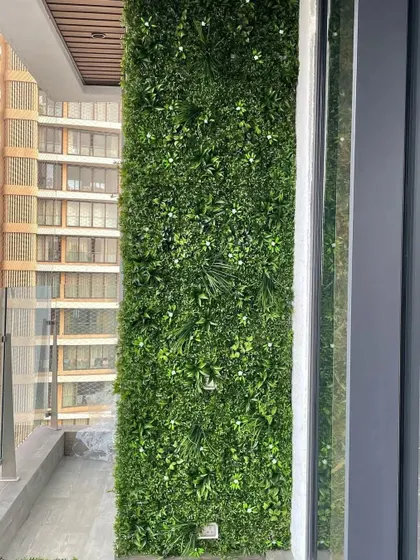 Even a small high-rise balcony can become a green oasis. This installation shows a dense, multi-textured artificial vertical garden that provides a beautiful view and requires zero maintenance, perfect for busy city life.