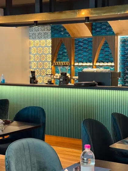 The bar at Maffei Kitchen, where our mixologists craft signature cocktails and pour fine wines. The ambient lighting and detailed tilework create a perfect backdrop for an evening drink.