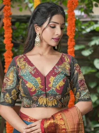 A full view of the model wearing the ornate chandbali earrings with her hand-painted Kalamkari blouse.