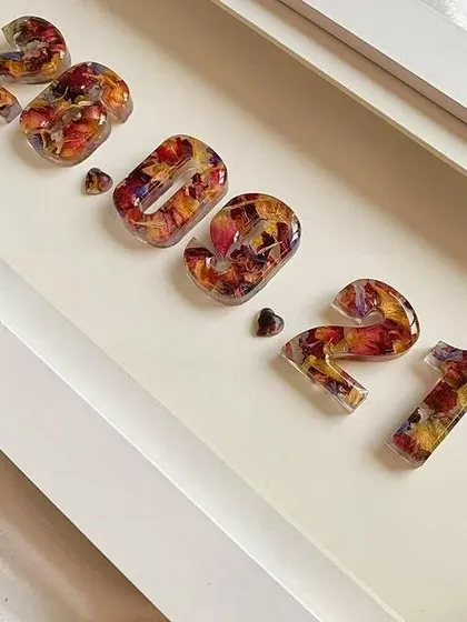 A close-up of a custom date frame, showing the beautiful detail of the flowers preserved within each number.
