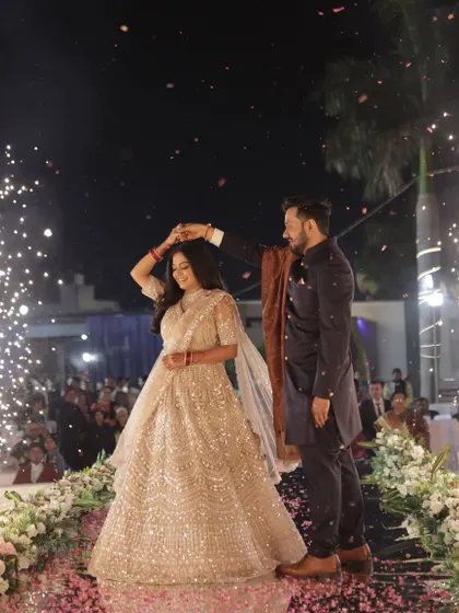 A fairytale dance moment on the reception stage, with the bride's lehenga and makeup catching the light perfectly.