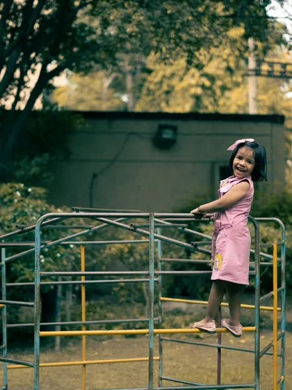 A wide shot showing the child in her play environment. This gives context and a sense of scale, creating a wonderful memory of a day at the playground.