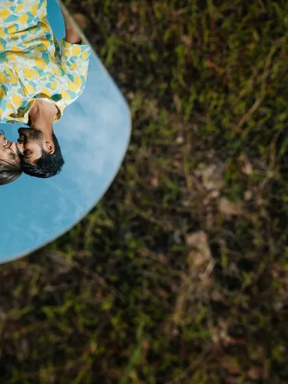 A creative shot using a mirror to reflect the couple lying on the grass. This unique perspective creates a playful and artistic image.