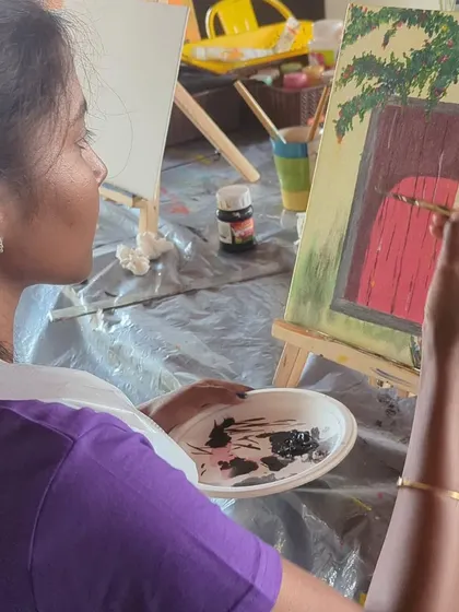 A participant painting a rustic door on canvas. Our guided sessions break down the process into simple, manageable steps.
