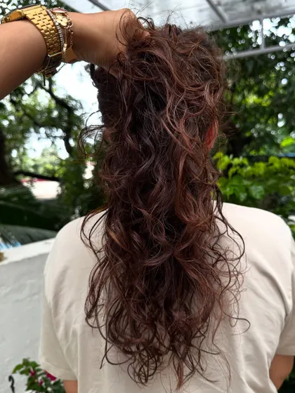 We call this "cascading hair." A shot of the curls being held up to show the waterfall effect of the layers and color.