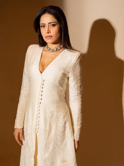 A close-up of Nushrratt in the ivory suit, focusing on the delicate choker and sharp V-neckline.