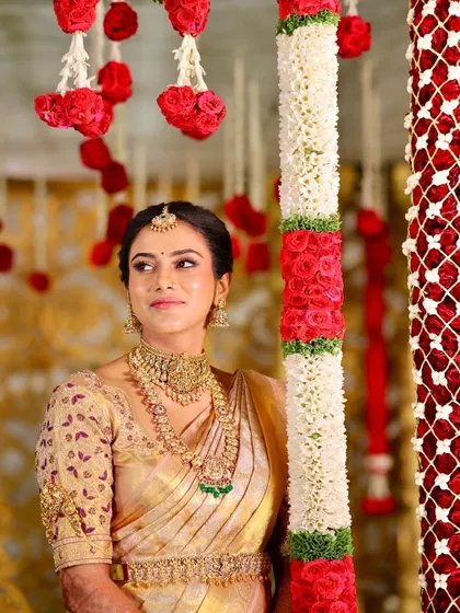 A beautiful candid shot from the wedding ceremony, showcasing the bride's glowing makeup against the vibrant backdrop of the floral decor.