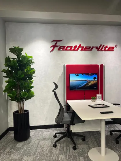 A tall artificial Fiddle Leaf Fig in a black fluted planter adds height and drama to this discussion pod at the Featherlite office. It's a great way to make a statement in a corporate setting.