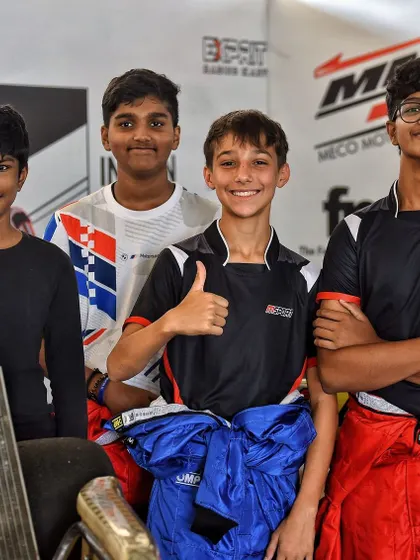 A group of young drivers in the pit lane, showcasing the camaraderie and focus within the paddock.
