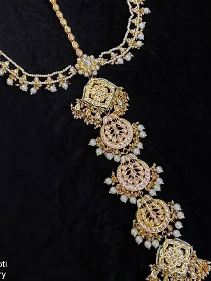 A 'Hair Choti' accessory or 'prandi' with intricate designs, perfect for decorating a bridal braid for a Punjabi or traditional look.
