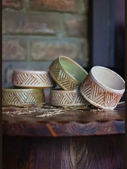 A stack of carved bowls from the KHUMĀR collection. These are perfect for serving nuts, dips, or other snacks during a get together.