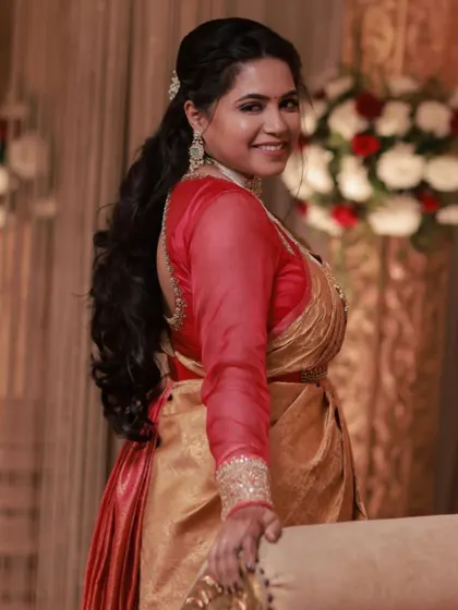A full-sleeve blouse can add so much class and richness to a silk saree. This bride looks regal in her red and gold reception saree with sheer embroidered sleeves.