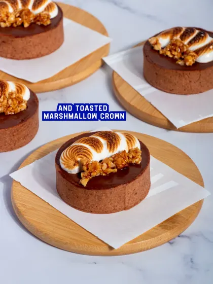 A platter of my S'mores Tarts, each with a crisp chocolate shell and a perfectly toasted marshmallow crown.