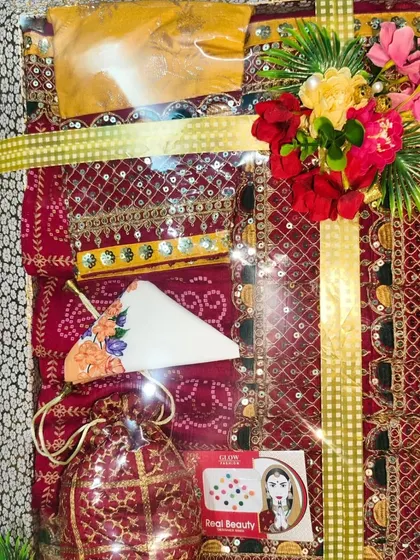 A traditional Bandhani suit set packed with a matching potli bag and other small shagun items.