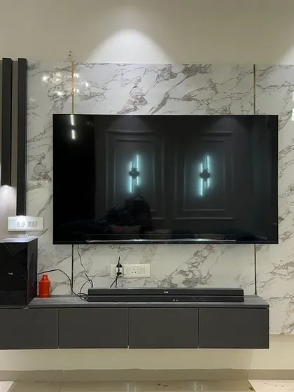 A sleek, modern TV unit setup. The floating console keeps the floor clear, and the vertical lighting element on the side adds a dramatic touch.