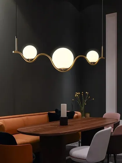 This wavy globe pendant light adds a touch of sophistication over a dining table, complementing both modern and classic decor.