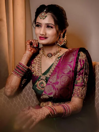 A candid moment showing her beautiful smile. The jewellery, including the choker, haram, and maang tikka, brings the whole look together.