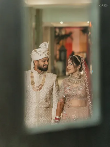 A stolen moment, captured through a reflection. The couple shares a look of love and admiration, a quiet conversation that no one else is a part of. These creative frames add a layer of artistry to your story.
