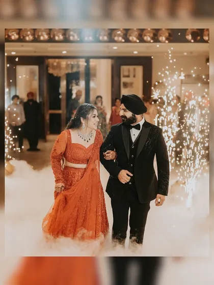 A grand entrance for a Sikh couple's reception. They walk through a cloud of dry ice and sparklers, creating a magical and celebratory moment.