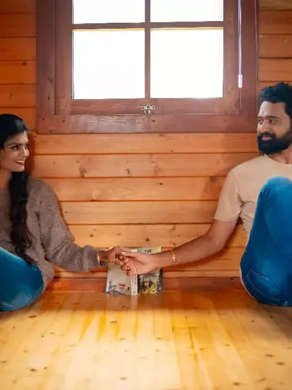 A sweet moment of connection, holding hands across the floor of a rustic wooden cabin. A simple and heartfelt pre-wedding photo.