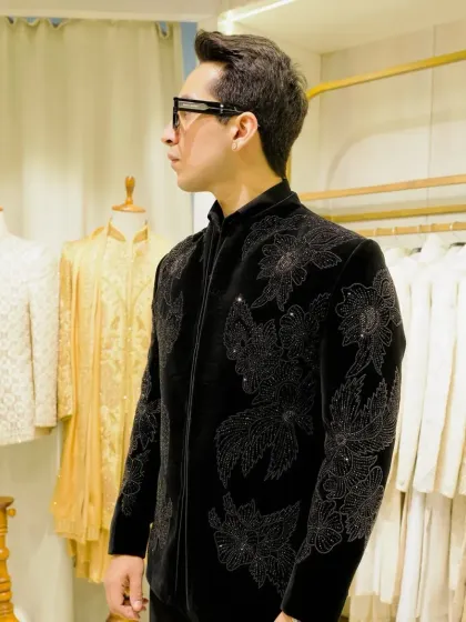 A client wearing a black velvet Jodhpuri with tonal black floral beadwork. The subtle texture and shine make it incredibly sophisticated.