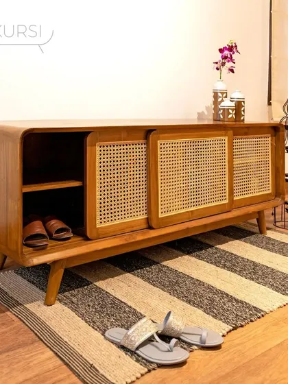 The 'Penthes' shoe rack in a home setting. Its sliding rattan doors keep footwear neatly hidden while adding a touch of natural texture to the entryway.