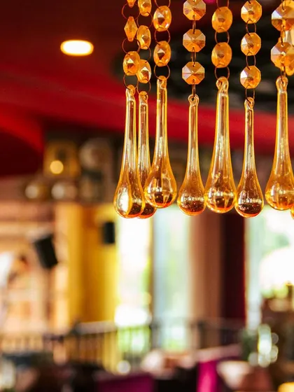 A restaurant is more than just a place to eat. It's a creative outlet, a space to socialize and connect. The details, like these amber chandelier drops, make all the difference.