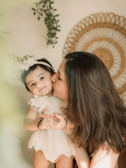 A close-up of a mother's gentle kiss on her daughter's cheek.