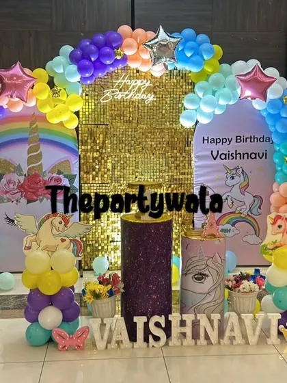 A vibrant unicorn theme with a rainbow balloon arch and a gold shimmer backdrop, perfect for a magical celebration.