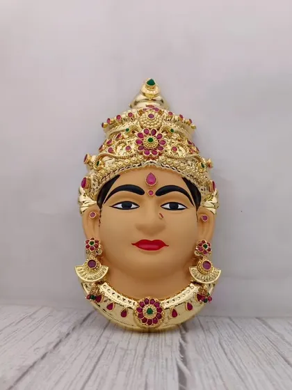 A hand-painted clay Lakshmi face with a serene expression, adorned with a golden crown and jewellery. Perfect for a traditional Varamahalakshmi setup.