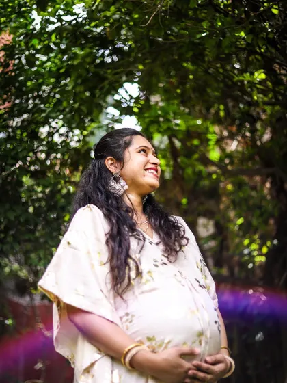 This is a portrait of pure joy. We used the natural garden light and a subtle lens flare to create an artistic, dreamy photo that captures the mother-to-be's happiness and excitement. This style of solo maternity portrait focuses on authentic emotion.