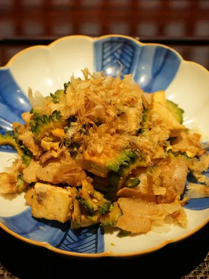 Goya Champuru, a classic Okinawan stir-fry. This "soul food" dish combines bitter melon, tofu, and tender pork, topped with dancing bonito flakes.