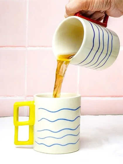An action shot of tea being poured into a quirky, modern mug. This dynamic photo brings the product to life and is highly engaging for social media.