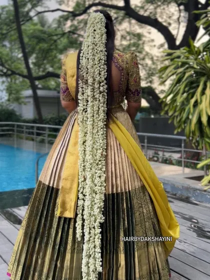 The complete 'Mogra' look by the poolside. The combination of the grand hairstyle and the flowing lehenga creates a truly magical and photogenic effect.