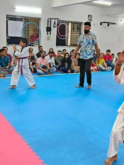 An instructor watches over students practicing their form.