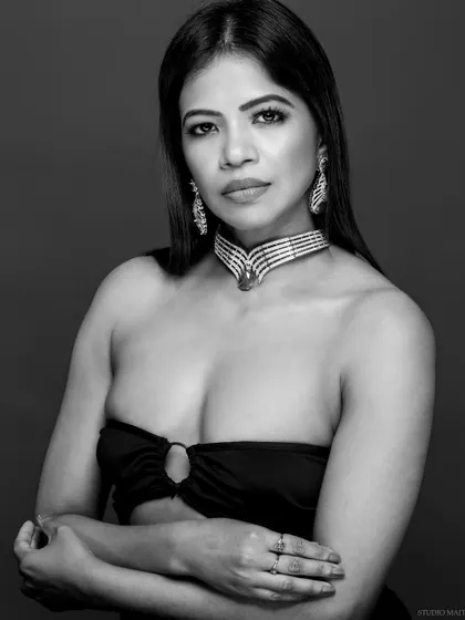 A black and white portrait of a model wearing a diamond and emerald choker.