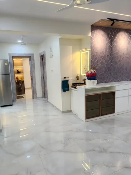 A wide shot of a completed living room project, showcasing the glossy marble-like flooring, custom furniture, and thoughtful lighting design.