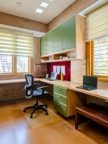 The L-shaped study table provides ample workspace, surrounded by the warmth of earth blocks.