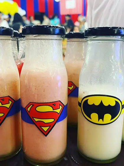 Even the drinks were on theme! We served milkshakes in these fun superhero-themed bottles, featuring logos like Superman, Batman, and Spiderman, adding another layer of detail to the kids' party.