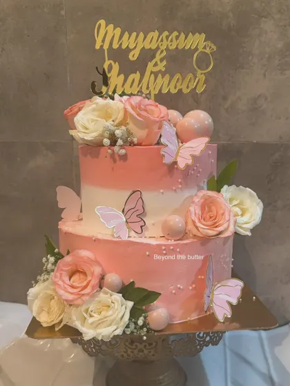 This two tier engagement cake is a vision in peach and pink. I used an ombre buttercream effect and decorated it with fresh roses and delicate butterflies for a whimsical touch.
