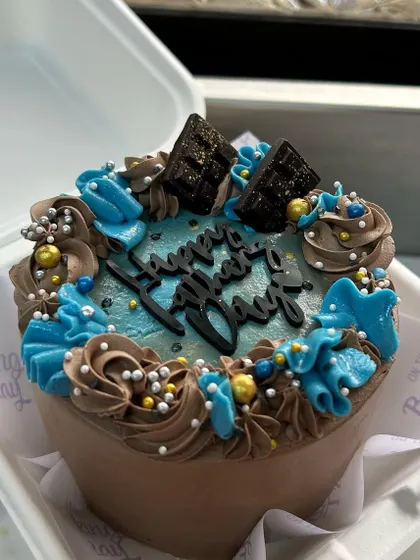 A special bento cake to celebrate Father's Day. I designed this one with blue and chocolate buttercream swirls and topped it with mini chocolate bars for a masculine yet celebratory look.
