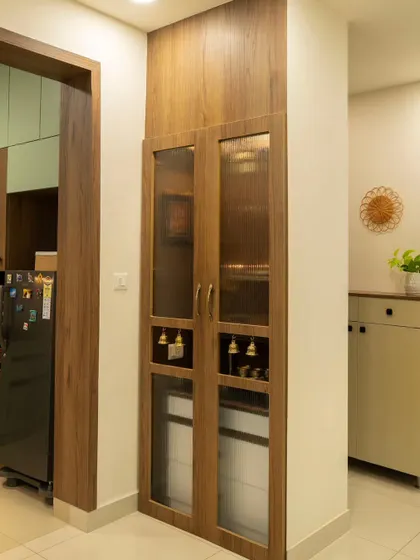 A compact, space-saving puja unit with fluted glass doors, designed to offer privacy while fitting perfectly into the home's layout.