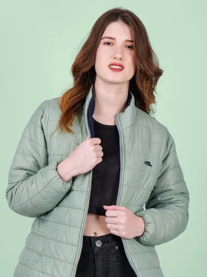 A model wearing a light green puffer jacket against a complementary pastel green background, creating a visually pleasing and cohesive look.