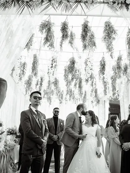 A black and white shot of the "I do" kiss during a Christian wedding ceremony. The monochrome edit focuses the viewer's attention on the emotion of the moment.