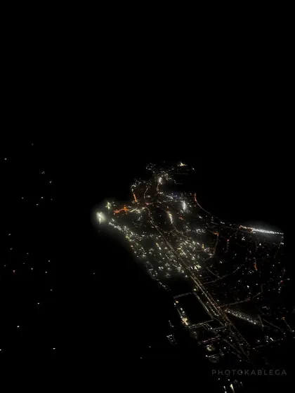 A wider aerial night view of South Mumbai, showing the peninsula illuminated against the dark sea. This shot gives a sense of the city's geography and scale at night.
