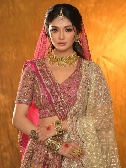 A blushing beauty in pink. This full bridal look features a stunning pink lehenga, complementary makeup, and exquisite jewellery.