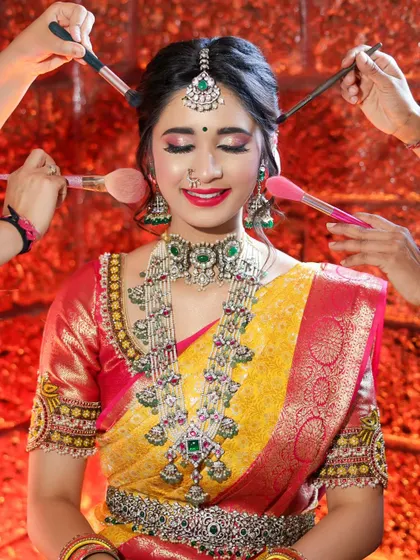 A creative shot of a model surrounded by makeup brushes. This "behind the scenes" style portrait is a fun and dynamic way to showcase the artistry of a bridal transformation.