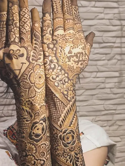 A heart with the couple's initials is a popular and romantic choice for personalizing your bridal mehendi.